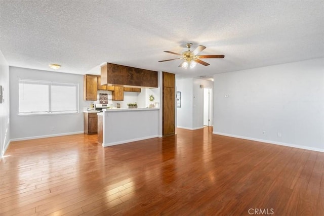 unfurnished living room with hardwood / wood-style floors, a textured ceiling, and ceiling fan