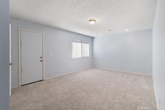 carpeted empty room with a textured ceiling