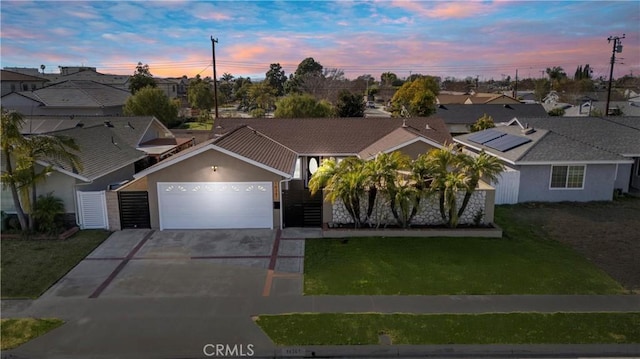 ranch-style house featuring an attached garage, a lawn, driveway, and stucco siding