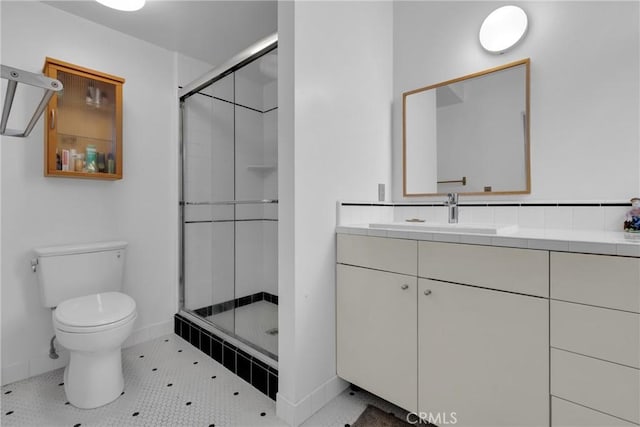 bathroom featuring vanity, tile patterned flooring, toilet, and walk in shower