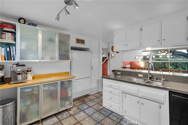 kitchen featuring dishwasher, white fridge, sink, and white cabinets