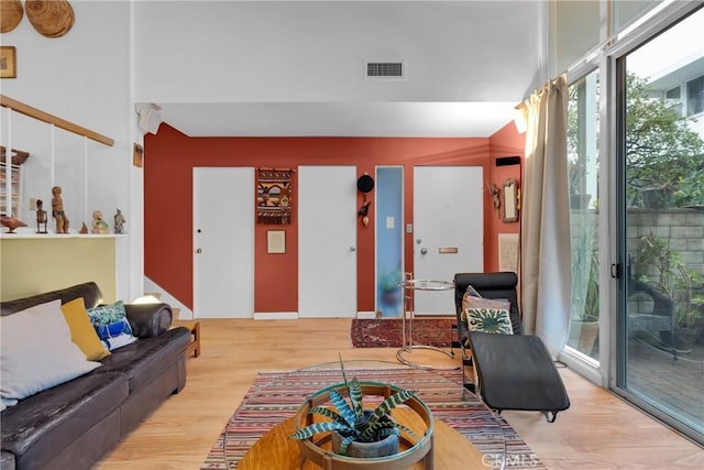 living room with a high ceiling and light wood-type flooring