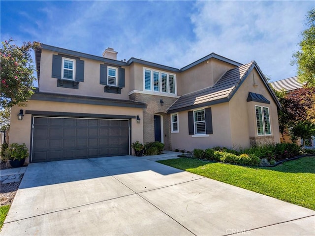 traditional home featuring a garage, driveway, brick siding, and a front yard