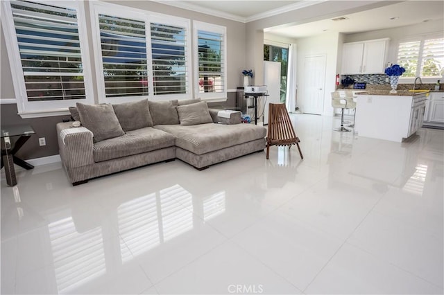 living room with ornamental molding, baseboards, and light tile patterned floors