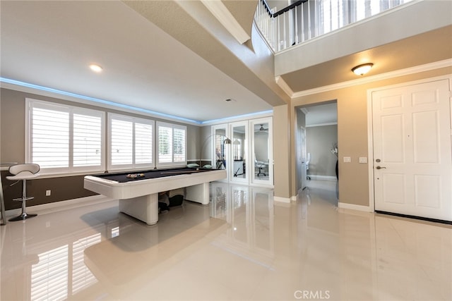 rec room featuring baseboards, tile patterned flooring, and crown molding