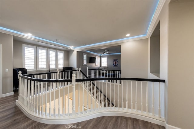 stairway featuring wood finished floors, baseboards, and ornamental molding