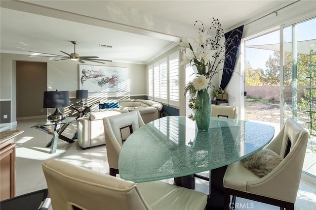 dining space with baseboards, ceiling fan, ornamental molding, and visible vents