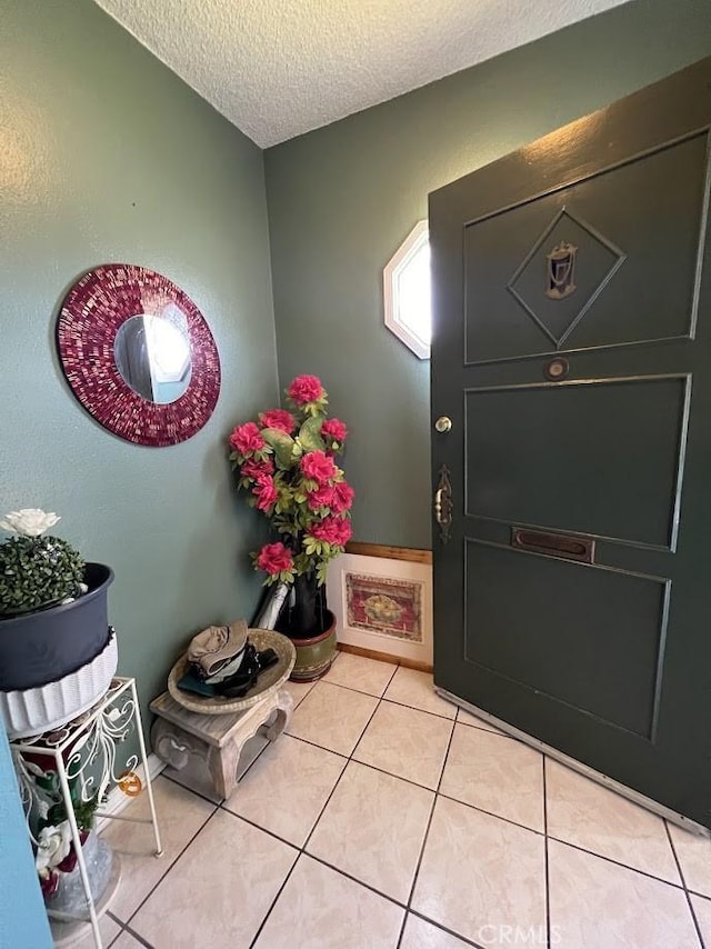 foyer entrance featuring light tile patterned flooring and a textured ceiling