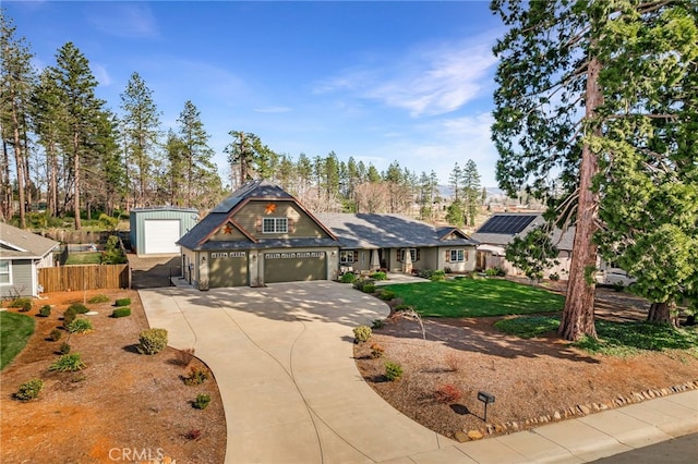 view of front facade featuring driveway, a front lawn, an attached garage, and fence