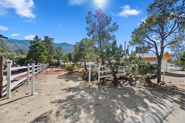 view of yard featuring a mountain view and fence