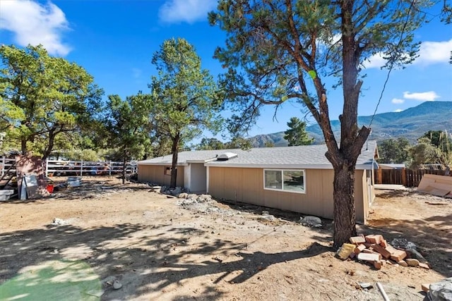 view of home's exterior featuring a mountain view and fence