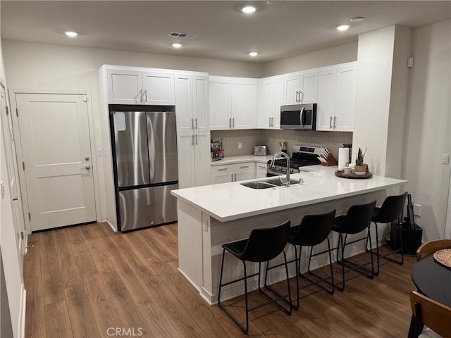 3620 S Allston Paseo Unit 7, Ontario, CA 91761 - kitchen with a breakfast bar area, stainless steel appliances, dark wood finished floors, a sink, and a peninsula