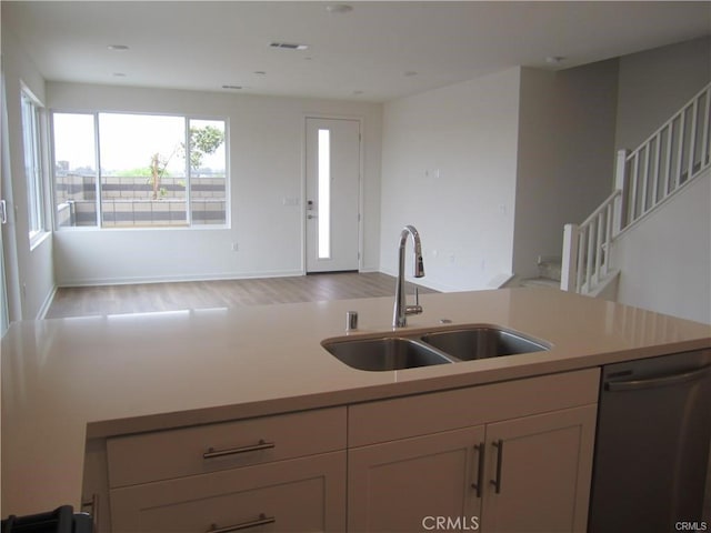 3620 S Allston Paseo Unit 7, Ontario, CA 91761 - kitchen with light countertops, dishwasher, wood finished floors, a sink, and open floor plan