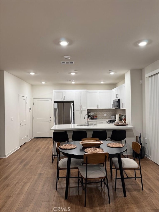 3620 S Allston Paseo Unit 7, Ontario, CA 91761 - kitchen with light countertops, a sink, visible vents, appliances with stainless steel finishes, and wood finished floors