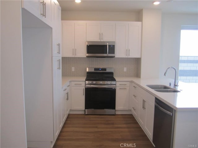 3620 S Allston Paseo Unit 7, Ontario, CA 91761 - kitchen with dark wood-style flooring, a sink, white cabinets, a peninsula, and appliances with stainless steel finishes