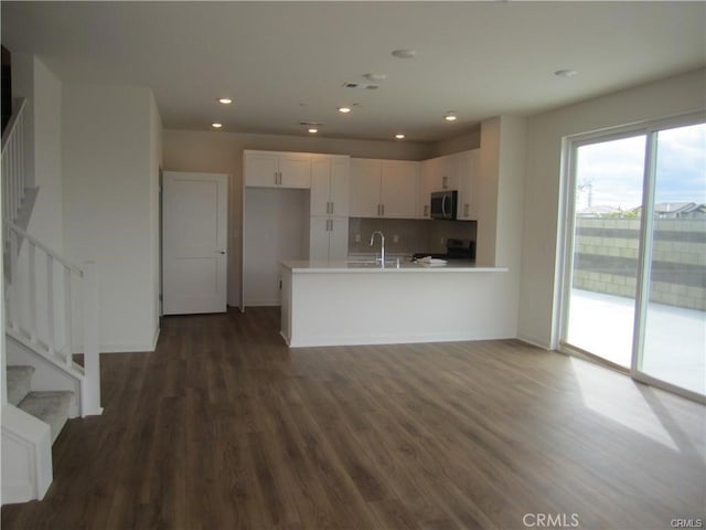 3620 S Allston Paseo Unit 7, Ontario, CA 91761 - kitchen featuring white cabinets, a peninsula, stainless steel microwave, electric stove, and a sink
