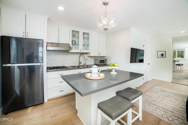 kitchen with white cabinets, appliances with stainless steel finishes, sink, and a breakfast bar area