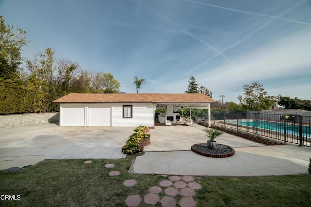 view of patio / terrace featuring an outdoor fireplace and a fenced in pool