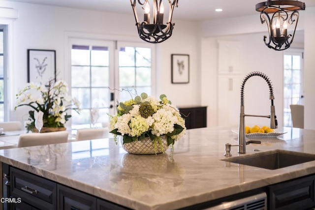 kitchen with hanging light fixtures, an inviting chandelier, sink, and plenty of natural light