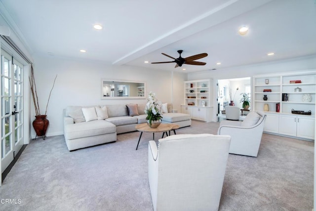 living room featuring beam ceiling, ceiling fan, crown molding, light carpet, and built in features