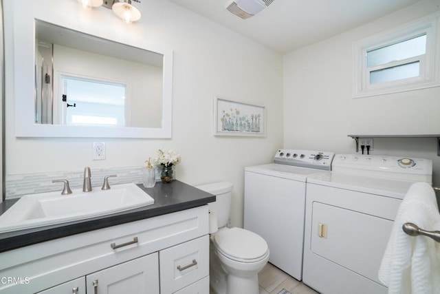 bathroom featuring toilet, vanity, and independent washer and dryer