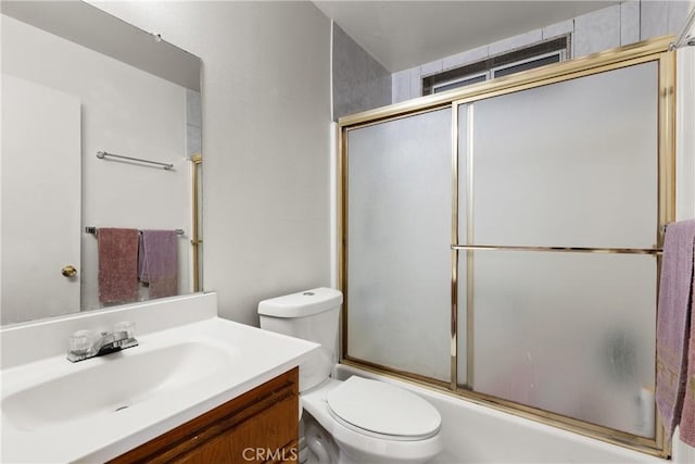 full bathroom with toilet, bath / shower combo with glass door, and vanity