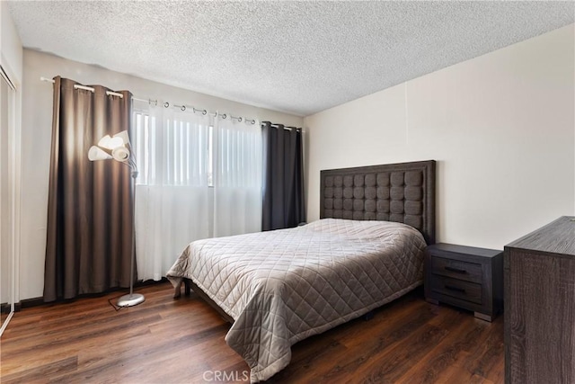 bedroom featuring dark hardwood / wood-style flooring and a textured ceiling