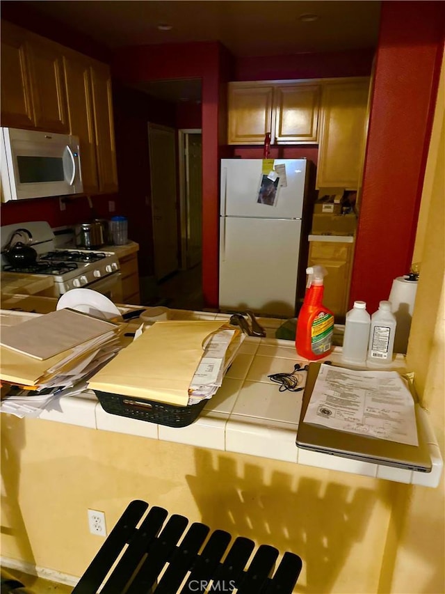 kitchen with white appliances and tile counters