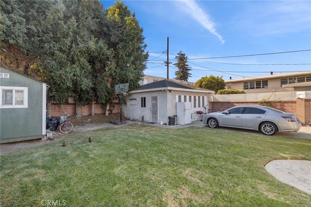 view of yard with a fenced backyard and an outdoor structure