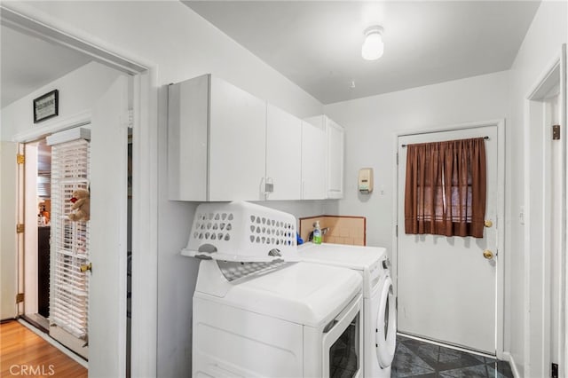 clothes washing area with cabinets and washing machine and clothes dryer