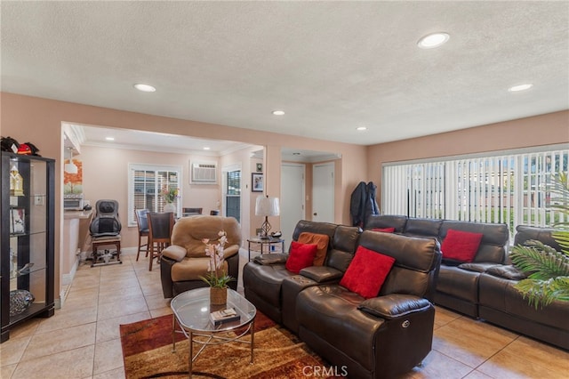 tiled living room featuring crown molding, a wall unit AC, and a textured ceiling