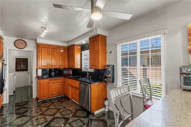 kitchen with sink, decorative backsplash, double wall oven, stainless steel dishwasher, and ceiling fan