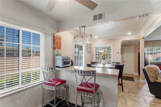 dining area with light tile patterned floors, ornamental molding, and ceiling fan