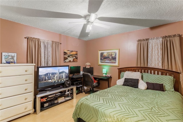 bedroom featuring ceiling fan, light hardwood / wood-style flooring, and a textured ceiling