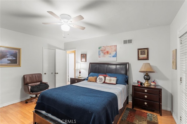 bedroom featuring visible vents, ceiling fan, baseboards, and wood finished floors