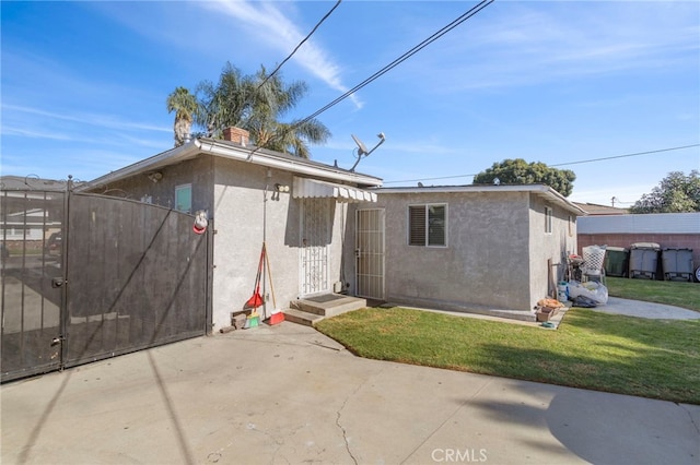 rear view of house featuring a patio area and a lawn