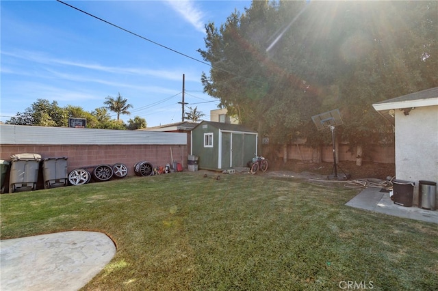 view of yard with a storage unit, an outbuilding, and fence