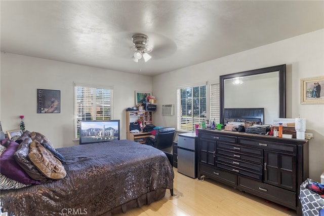 bedroom featuring multiple windows, ceiling fan, refrigerator, and light wood-type flooring