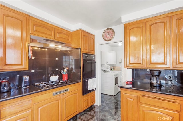 kitchen with tasteful backsplash, black double oven, washer / dryer, and gas stovetop