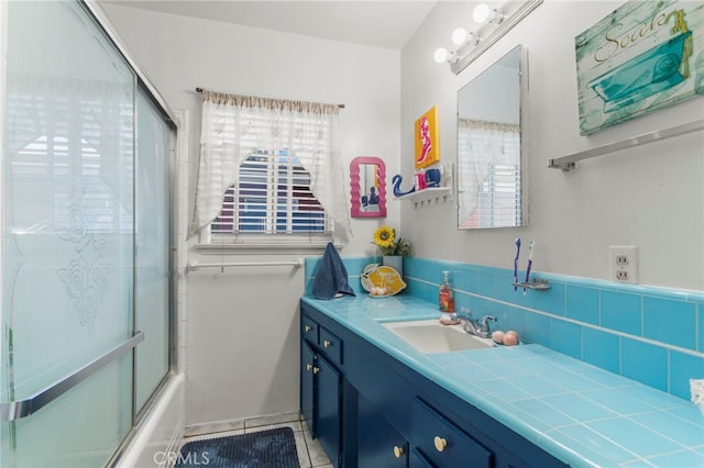 bathroom featuring bath / shower combo with glass door, vanity, tile patterned flooring, and plenty of natural light