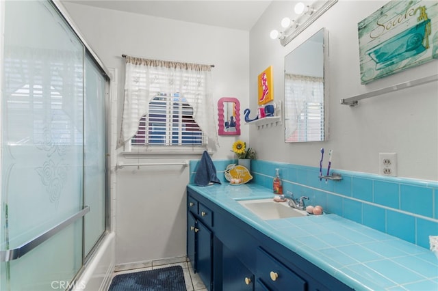 full bathroom featuring tile patterned floors, plenty of natural light, shower / bath combination with glass door, and vanity