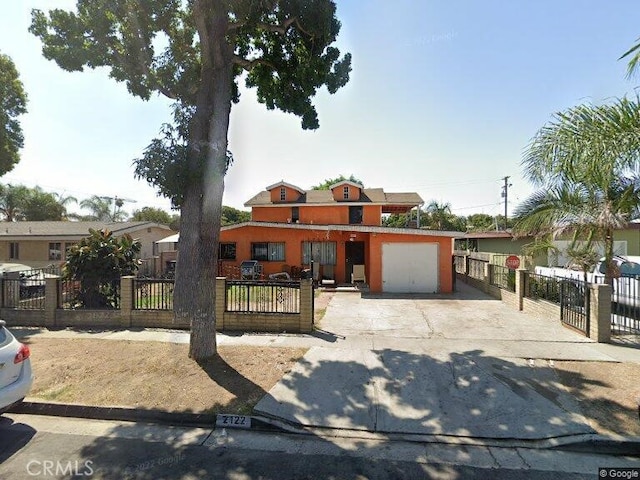 view of front facade featuring a fenced front yard, a garage, and driveway