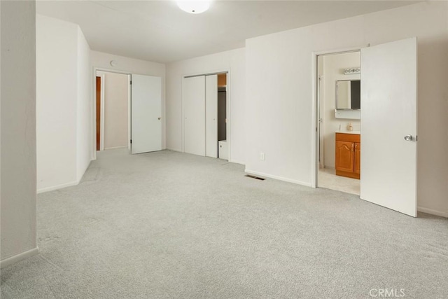 unfurnished bedroom featuring a closet, light carpet, visible vents, and baseboards