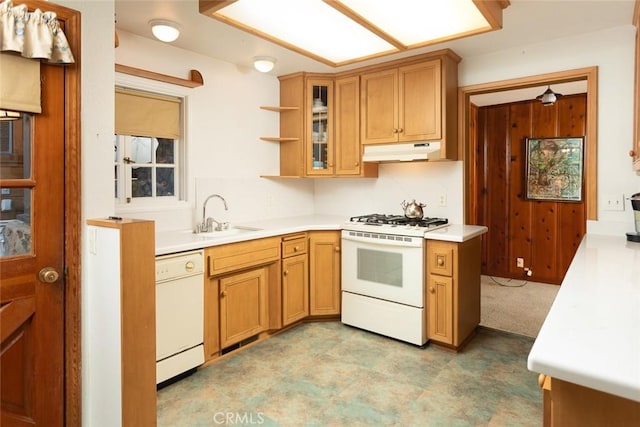 kitchen featuring light countertops, glass insert cabinets, a sink, white appliances, and under cabinet range hood