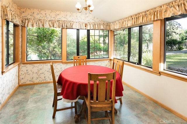 dining area featuring lofted ceiling, wallpapered walls, baseboards, and a chandelier