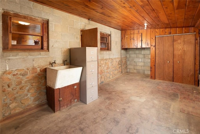 basement featuring wooden ceiling and a sink