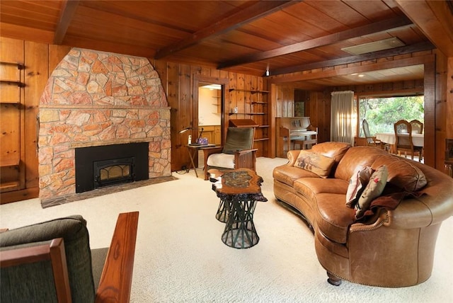 living area with a stone fireplace, wooden ceiling, wooden walls, carpet flooring, and beam ceiling