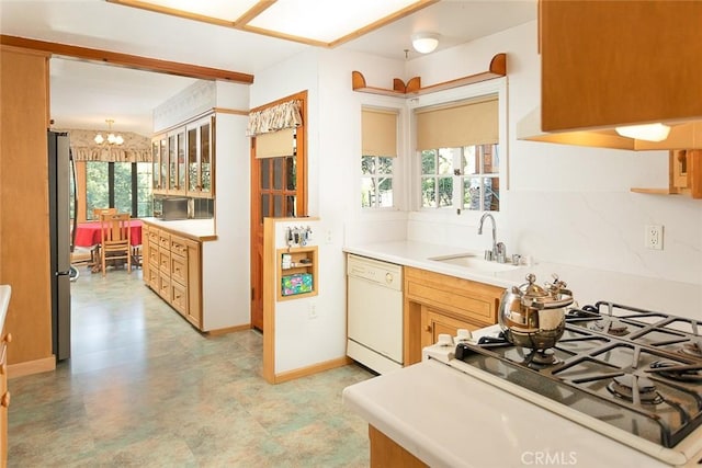 kitchen featuring tasteful backsplash, dishwasher, glass insert cabinets, freestanding refrigerator, and light countertops