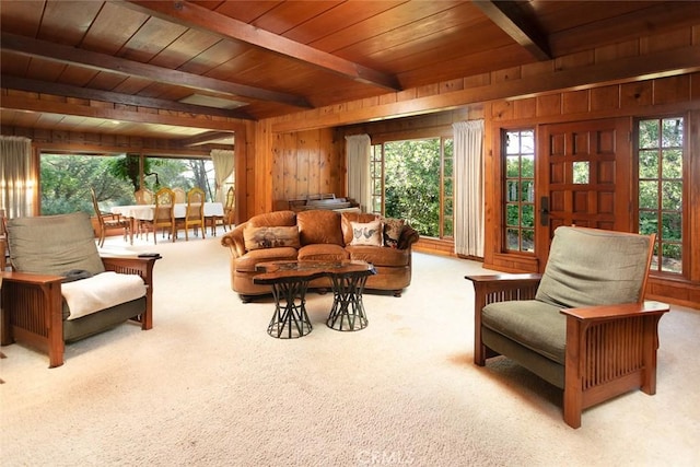 sitting room featuring wooden ceiling, wooden walls, beam ceiling, and light colored carpet