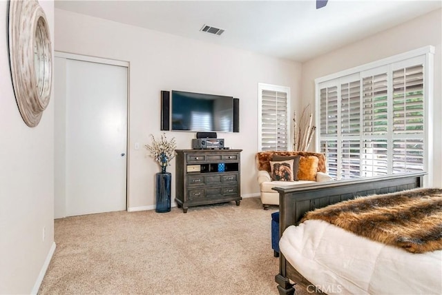 bedroom featuring light carpet, a ceiling fan, visible vents, and baseboards